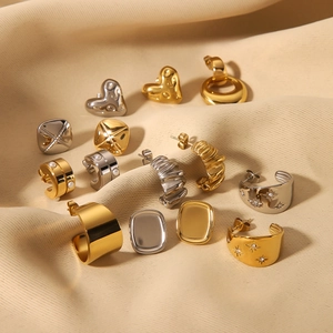 Various gold and silver C-shaped and heart-shaped stainless steel earrings on silk