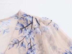 Vue détaillée d'une robe en mousseline fleurie à col en V avec imprimés et manches bouffantes