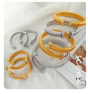 Detail of gold and silver spiral bracelets and hoop earrings with sparkling rhinestones