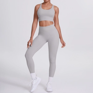 Vista laterale del set yoga grigio chiaro con reggiseno incrociato e leggings a vita alta