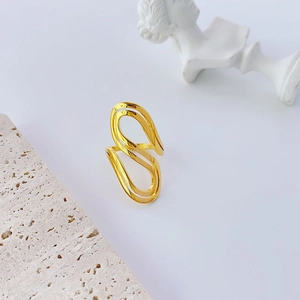 Gold wavy stainless steel open ring displayed on minimalist aesthetic stone background