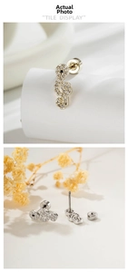 Macro view of treble clef ear stud with cubic zirconia and threaded flat back design