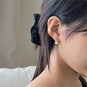 Elegant model shot of a minimalist gold pearl earring showing detailed side-ear placement