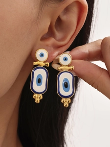 Detailed view of evil eye earrings featuring blue enamel and gold-plated titanium steel