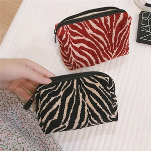 Close-up of zebra pattern corduroy makeup bags with sturdy black zipper closure
