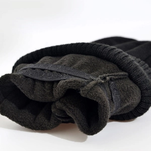 Close-up of ribbed knit cuffs and warm black fleece lining on winter sports gloves