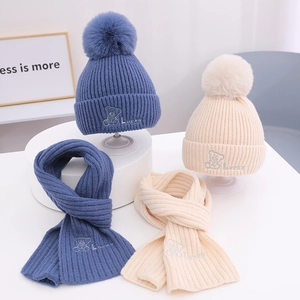 Detailansicht des Winter-Stricksets mit Bärenstickerei und flauschigem Bommel-Akzent