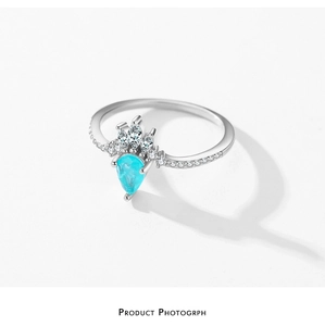 Macro shot of silver ring with pear-cut sea blue stone and marquise diamond accents