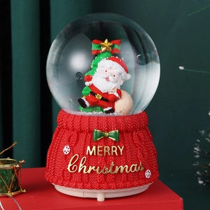 Detail of Christmas crystal ball with Santa and red knit texture base merry christmas