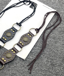 Detailed view of three vintage leather belts in black, dark brown and light brown shades