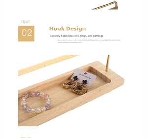 Detail of jewelry organizer with gold hooks and wood base showing clover earring and bracelet