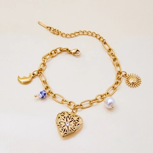 Detail of gold multilayer bracelet with hollow heart pendant and stainless steel charms