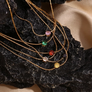 Macro view of 18K gold plated necklaces with colorful zircon pendants on black stone