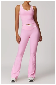 Detail of pink yoga top with white trim and high-waist flared pants on a model