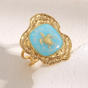 Detail of vintage 18K gold plated turtle ring with turquoise enamel and hammered edges