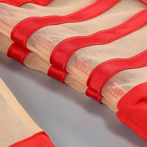 Macro detail of red wavy satin ribbons stitched onto sheer mesh fabric for a slim dress