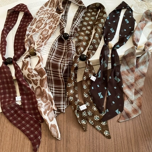 Flat lay of vintage chiffon neckerchiefs with retro bead accents and various patterns