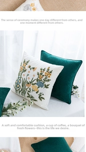 Detail of floral embroidery on cotton canvas and dark green velvet decorative cushions