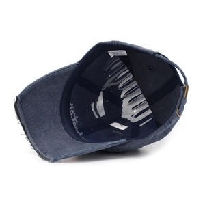 Detail of blue distressed baseball cap featuring internal lining and adjustable metal buckle