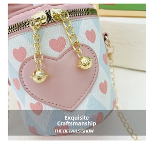 Detailed close-up of pink heart bucket bag featuring gold chain and hardware accents