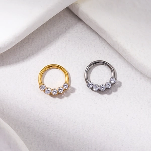 Close-up of gold and silver G23 titanium rings set with five sparkling zircon stones