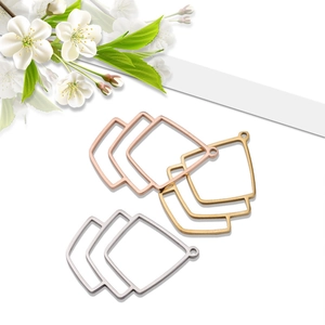 Detail of geometric trapezoid metal earring charms in gold, silver, and rose gold finishes