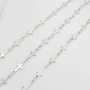 Macro detail of silver cross-shaped metal chain links for DIY jewelry making and crafts