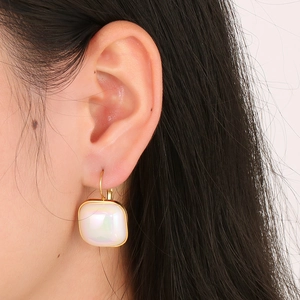 Boucles d'oreilles vintage en or avec perle sirène irisée sur un mannequin femme