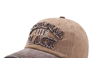 Detail of vintage washed cotton baseball cap with embroidered patch and frayed edges