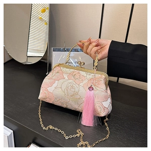 Detail of pink floral embroidery and fringe on a vintage-style shell crossbody bag