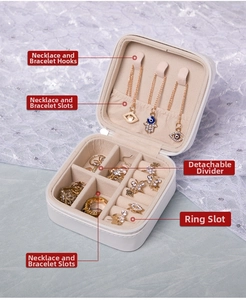 Detail of portable jewelry box featuring 3 necklace hooks and a beige velvet interior
