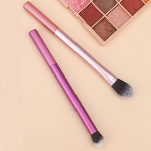 Detail of pink and purple professional makeup brushes with soft bristles and eyeshadow palette