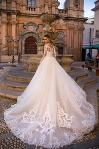 Vue arrière d'une robe de mariée en dentelle ivoire avec longue traîne et broderie fine