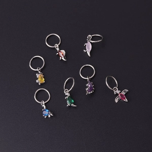 Close-up of colorful zircon dinosaur charms on stainless steel rings in various colors