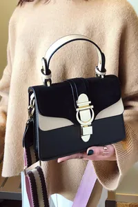 Detail of vintage crossbody bag with gold ring buckle and woven striped shoulder strap