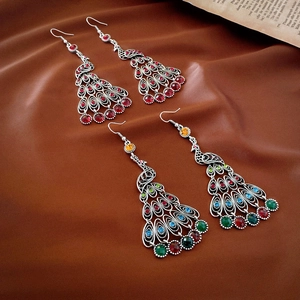 Vintage peacock tassel drop earrings with colorful rhinestones on brown silk background