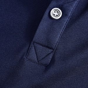 Detailed close-up of navy piqué cotton polo shirt showing button placket and reinforced stitching