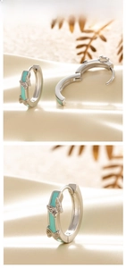 Vue détaillée de boucles d'oreilles papillon en émail bleu sarcelle sur soie beige