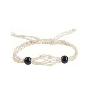 Detail of handmade cream woven cord necklace featuring two polished black decorative beads