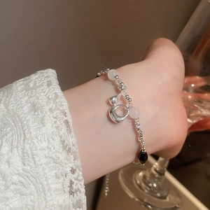 Dettaglio di un bracciale in argento con ematite nera e perle sulla caviglia di una donna