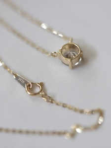 Macro shot of S925 hallmark on a 14K gold plated silver necklace with zircon pendant