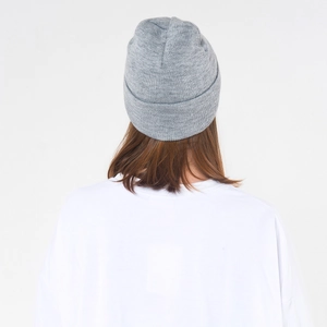 Detail view of a light grey knitted beanie with fine stitch patterns and ribbed edge for winter