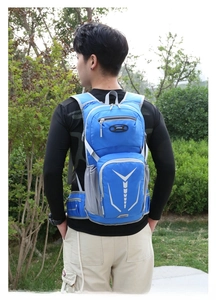 Blue cycling backpack with breathable straps and reflective safety strips on outdoor trail