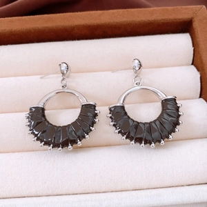 Detail of vintage silver earrings with dark leather wrap on beige velvet background