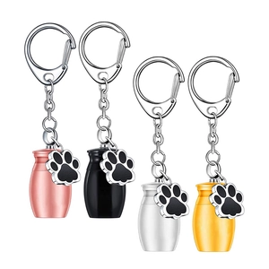 Set of four cylinder pet cremation urn keychains with paw charms in gold, silver, pink, black