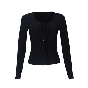 Close-up of black ribbed knit long sleeve top featuring lace-up front and button details