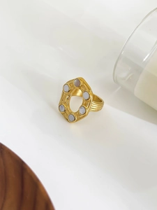 Macro shot of 18K gold irregular hollow ring set with white mother of pearl inlay