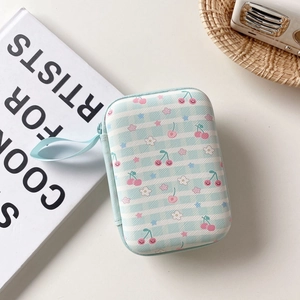 Detail of blue striped fruit pouch for earphones and cables with red cherry pattern