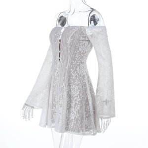 Détail d'une robe en dentelle blanche avec crochet floral et manches longues dénudées