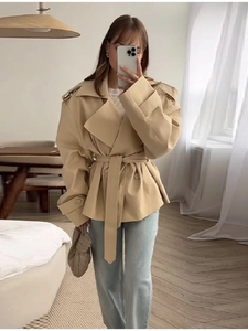 Dettaglio del trench corto color kaki con cintura e collo a revers da donna